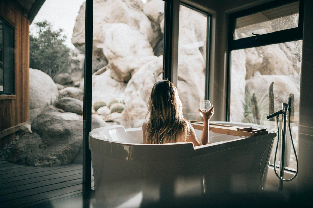 Woman in bathtub with wine glass